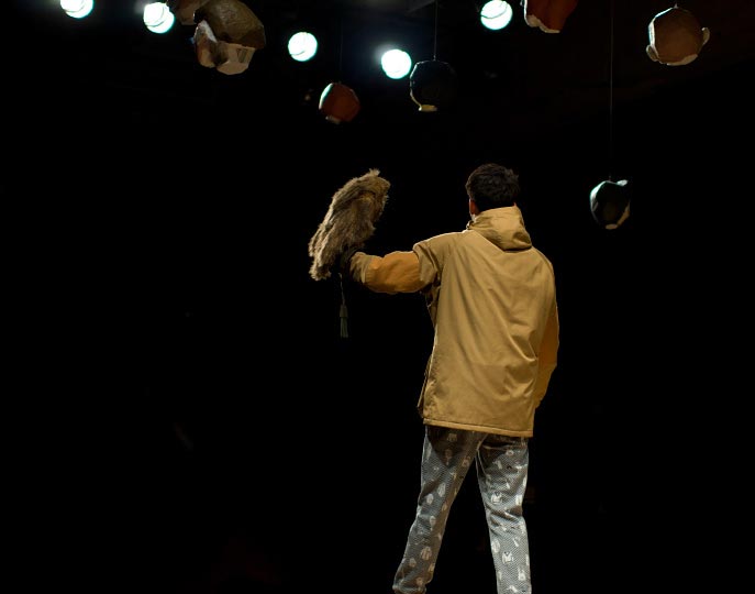 A horizontal picture of a man holding his arm up with a stuffed bird pirched on it at the end of the runday during Ne-nets show at Tokyo Fashion Week spring 2012 Photo by Artist Danny Roberts